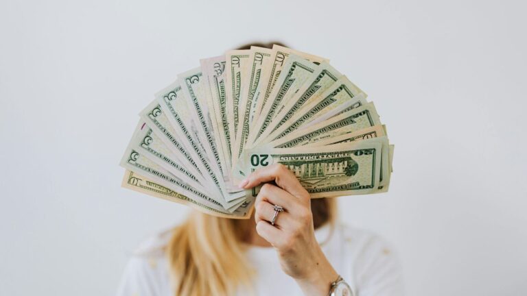 Woman Holding Fan of US Dollar Bills