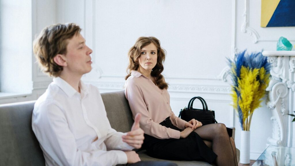 Woman in Black Dress Sitting Beside Man in White Dress Shirt