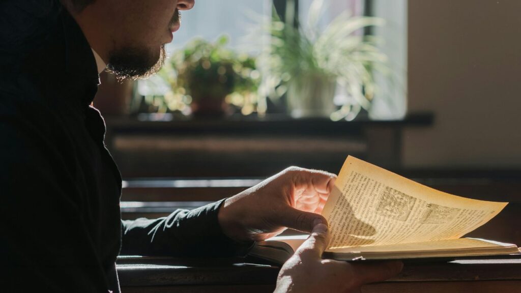 A Man Reading a Religious Book