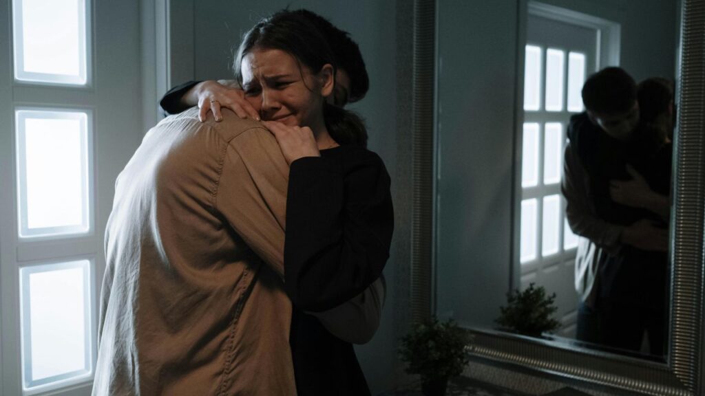 An Emotional Woman Crying while Hugging another Person