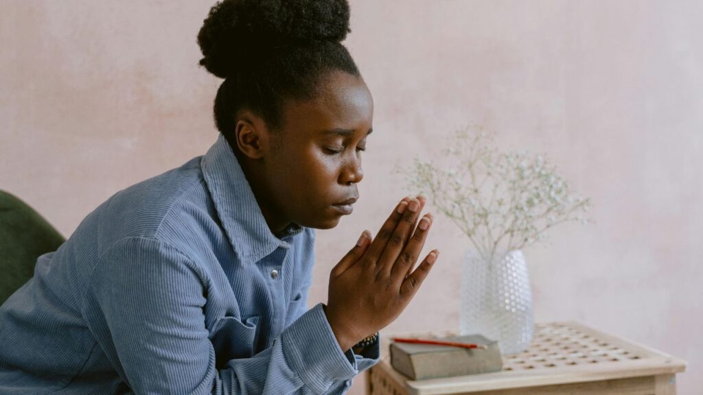 Woman in Blue Dress Shirt Praying
