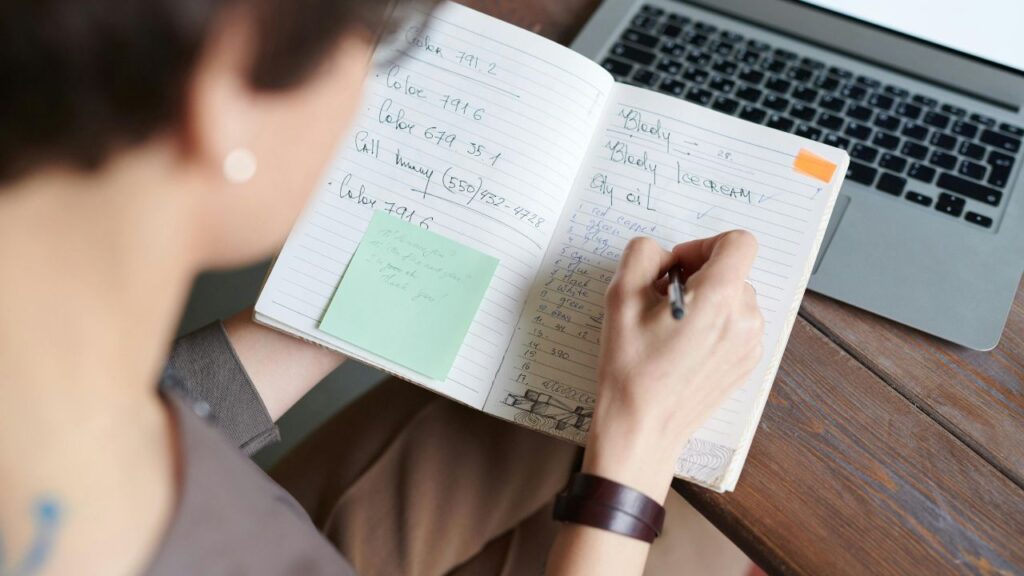 Photo Of Person Writing On Notebook