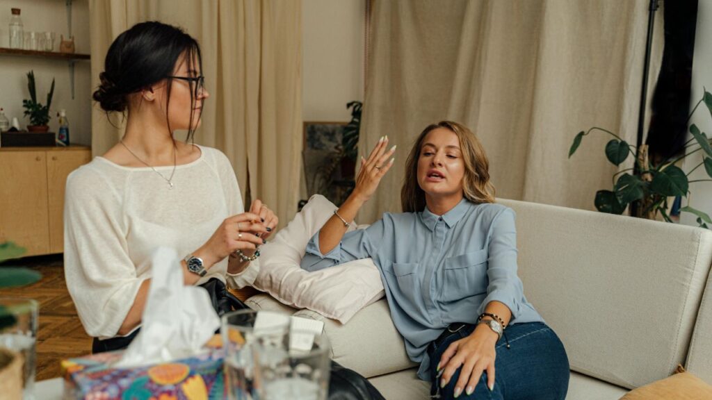 Woman in White Long Sleeve Shirt Sitting Beside Woman in White Long Sleeve Shirt
