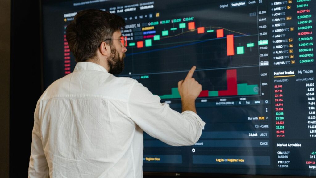 Man in White Dress Shirt Analyzing Data Displayed on Screen