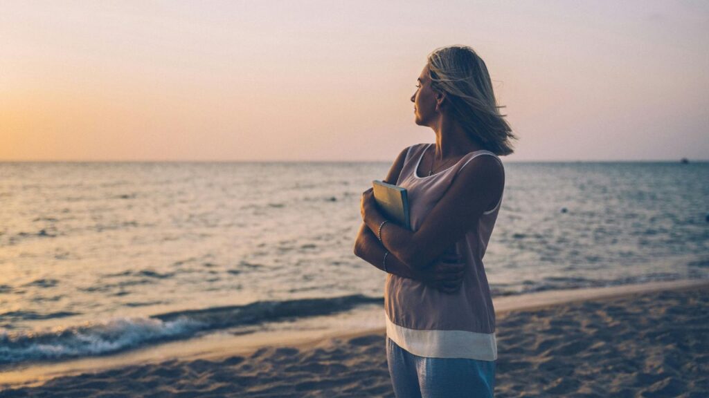 Woman Wearing Sleeveless Top Standing on the Beach during Sunset