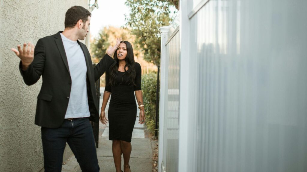 Man in Black Suit Standing Beside Woman in Black Dress