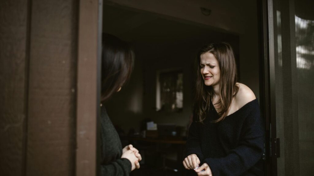 Two Women Sharing Emotional Moment by the Door