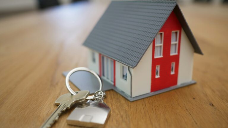 white and red wooden house miniature on brown table