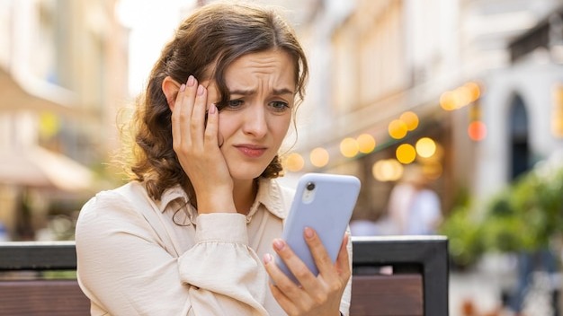 Surprised young woman use smartphone loses bad news fortune loss fail outdoors in city street