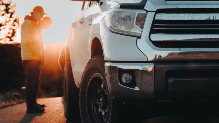 a man standing next to a white truck