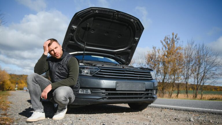 Man with broken car in the middle of the road