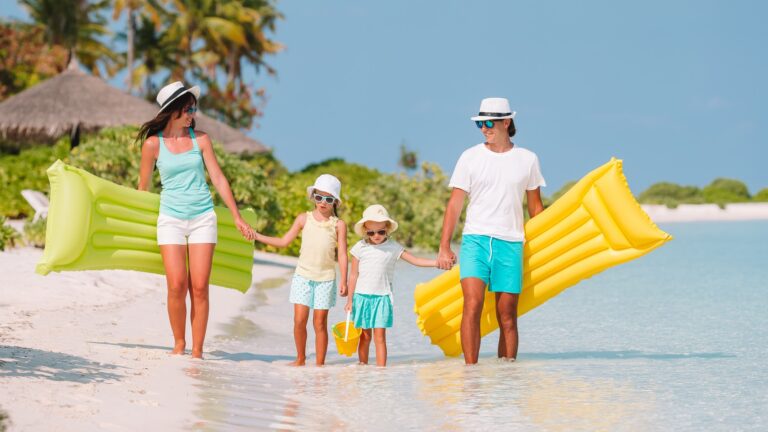 Family of four on beach vacation have fun