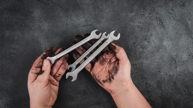 Holding wrench tools in the hands covered with fuel oil, repairing tools, industrial worker