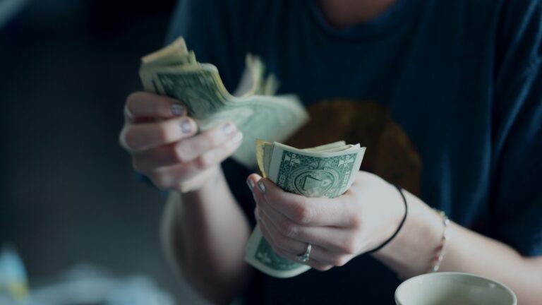focus photography of person counting dollar banknotes