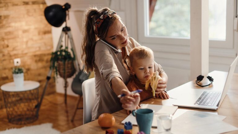 Multitasking mother taking care of her small son while working at home