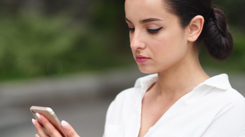 Closeup girl using mobile phone outdoors Businesswoman using phone after work