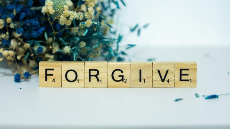 a wooden block that says for give next to a bouquet of flowers