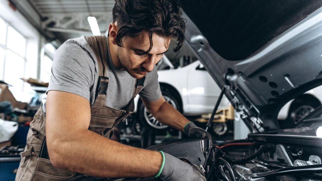 Mechanic examining car in auto car repair service center