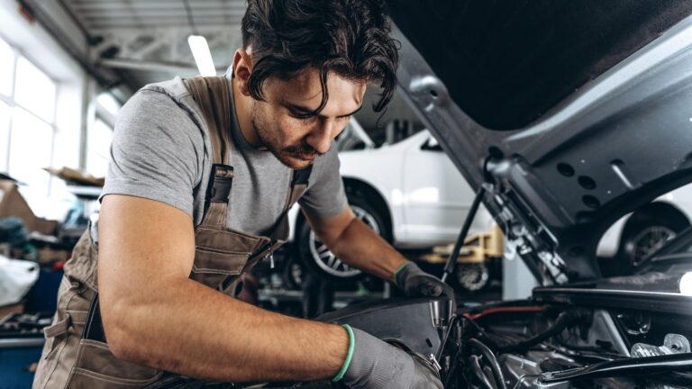 Mechanic examining car in auto car repair service center