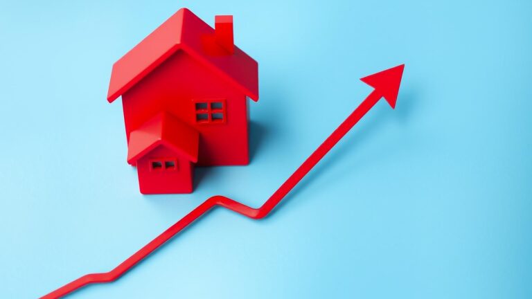 Rising property values concept with red house layout on rising red line graph on abstract blue backg