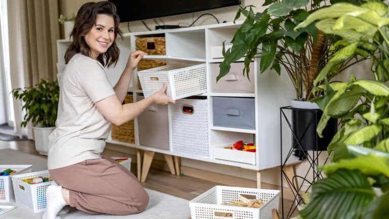 Smiling female housewife childish toys storage organizing sorting details with basket pvc container