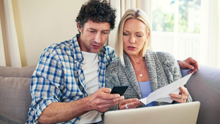 Laptop house and bills for man woman and reading in living room phone and loan debt and documents Lounge tax and male person with partner paperwork and expenses online and budget for cost