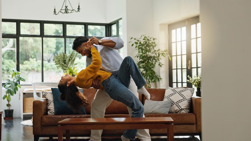 Home dancing and couple in lounge love and bonding together with romance smile and relationship Apartment movement and man with woman marriage and happiness with music energy and celebration