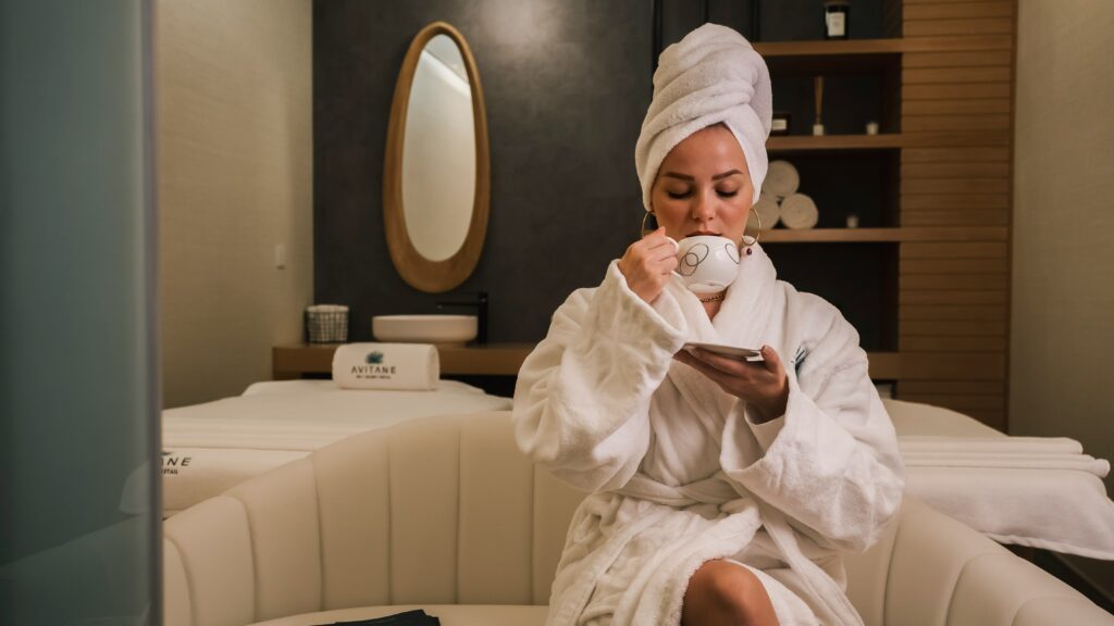 woman in white robe sitting on white couch