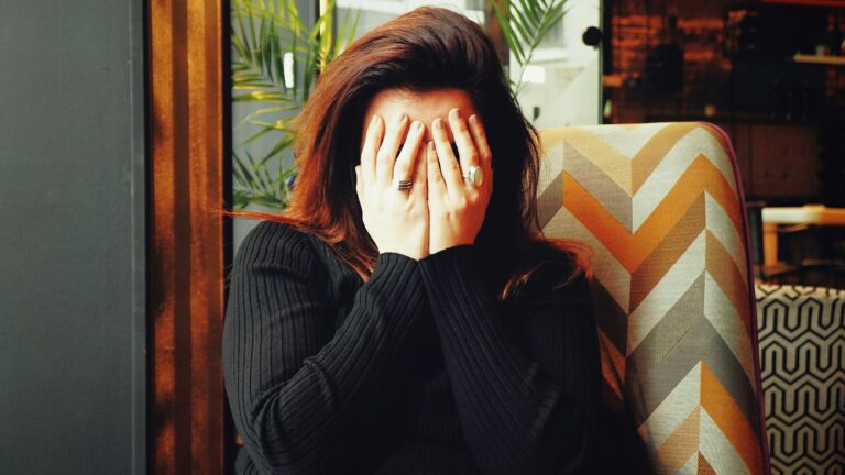 woman in black long sleeve shirt covering her face