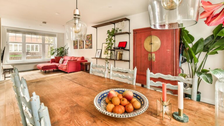 A dining room table with a bowl of fruit on