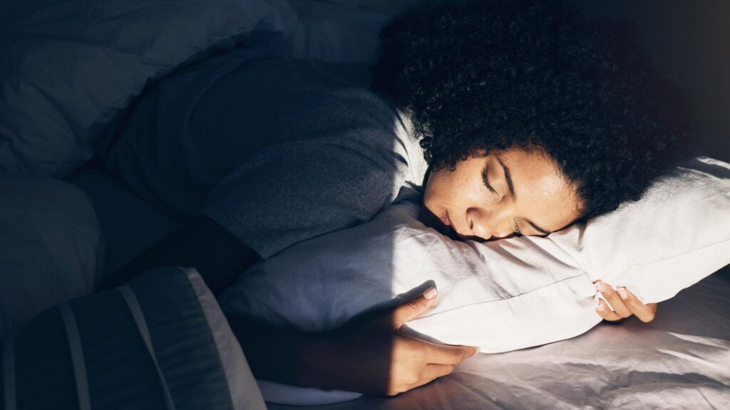 Black woman bed and sleeping at night for peace quiet and rest or relax in home bedroom Person with pillow to dream security or for calm sleep with nap or comfort with duvet for wellness