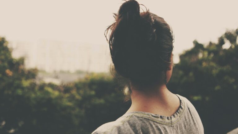focus photography of woman facing trees