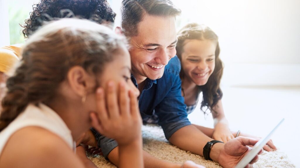 Floor family and tablet for streaming online and series or movies for entertainment Smile dad and children people for digital and bonding technology and carpet in living room of home for media
