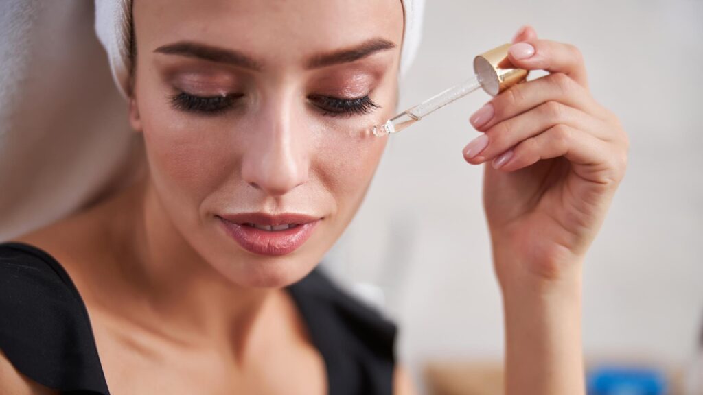 Relaxed young lady using hyaluronic acid on her face