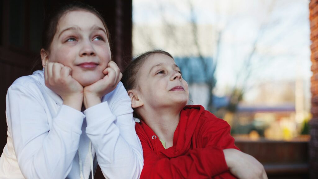 a person and a girl sitting on a bench