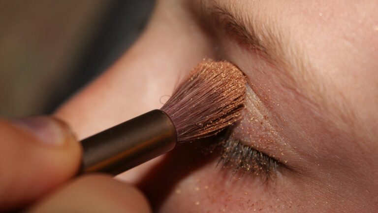 woman applying brown glittered eyeshadow