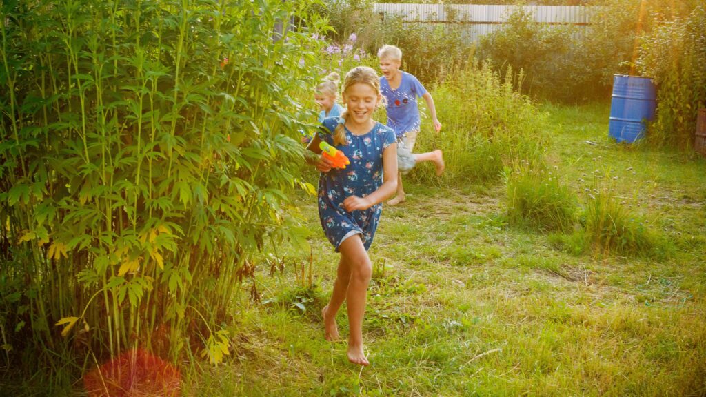 girl in blue and white shirt standing on green grass field during daytime