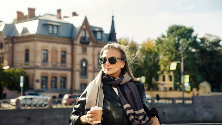 a person holding a drink and standing on a street