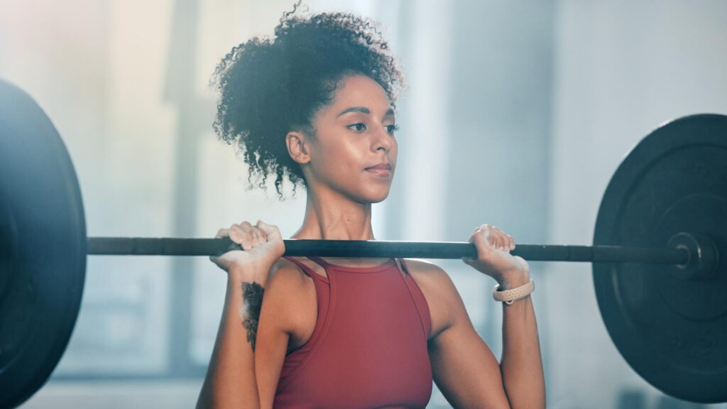Gym barbell workout and black woman doing muscle fitness performance strength training or bodybuilding Strong exercise girl body health or bodybuilder weightlifting for athlete wellness lifestyle