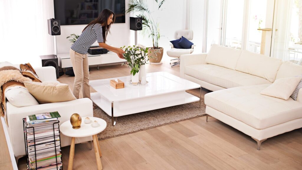 Young woman tidy living room and home with plants interior design job or cleaning service with style Girl house and organized for clean lounge furniture or apartment with flower bouquet on table