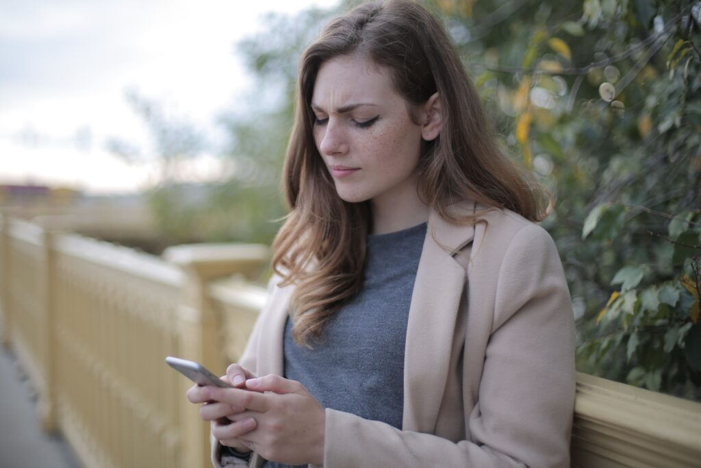 tired woman looking at cell phone