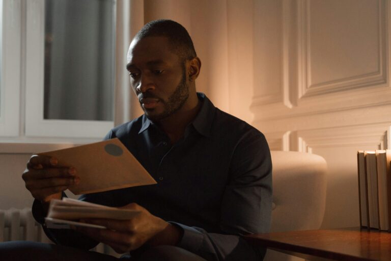 man at home looking at letter