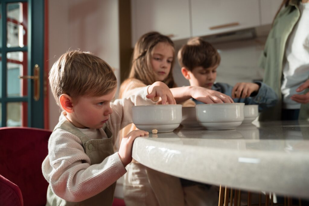 children in kitchen eating cereal