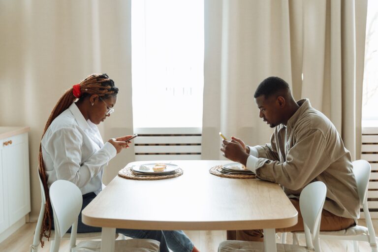 man and woman on phones ignoring each other