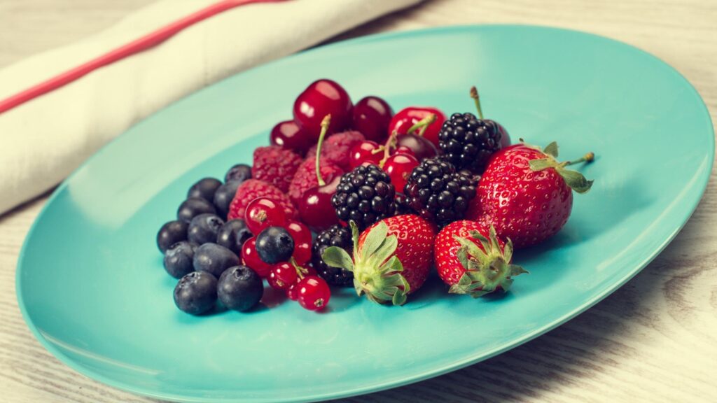 Berries on a blue plate on a wooden table