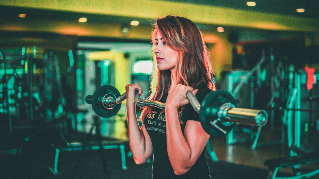 woman lifting black and gray barbell