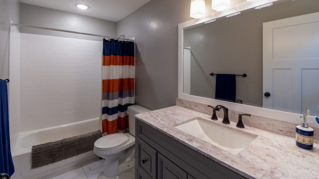 Bright and minimalist bathroom with a modern vanity and colorful shower curtain.