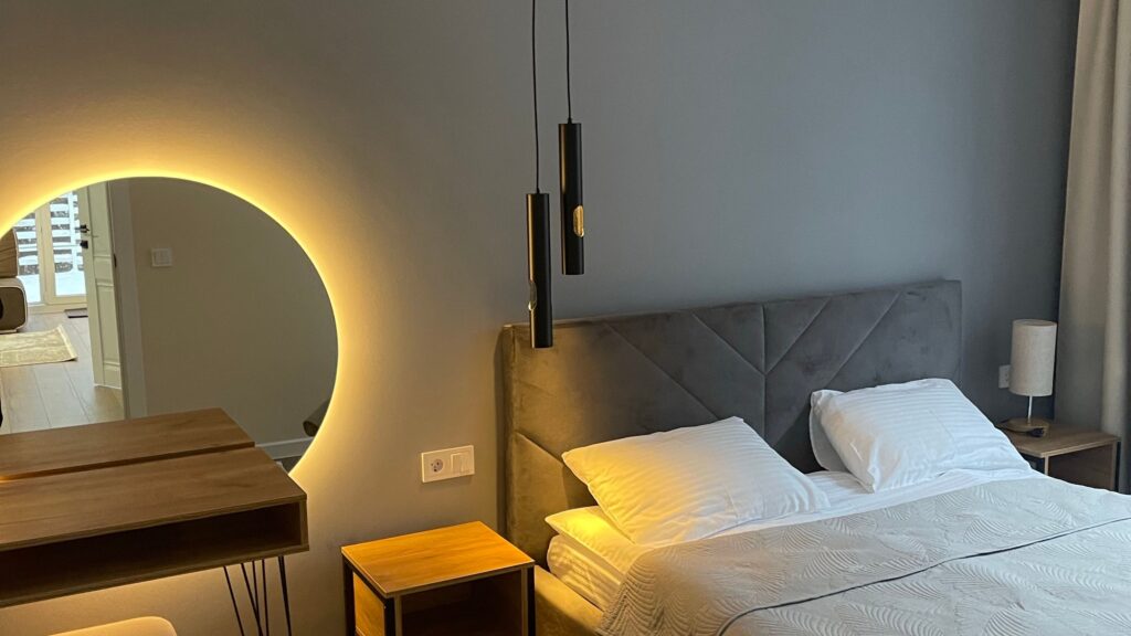 Contemporary hotel bedroom with elegant decor and soft lighting for a cozy ambiance.
