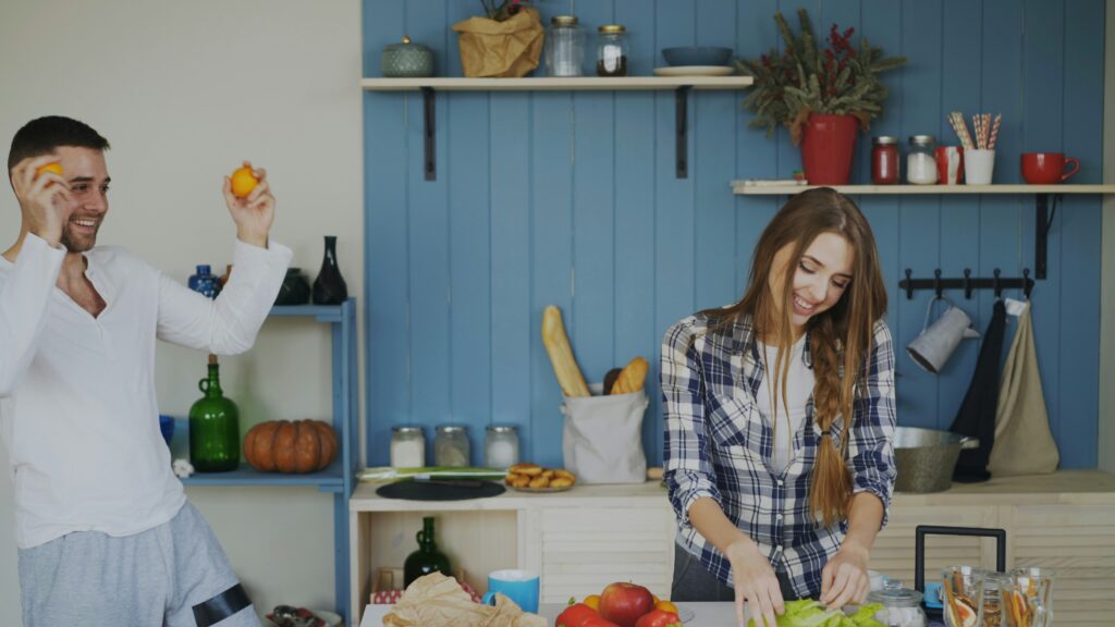 Couple happily preparing food and dancing in kitchen