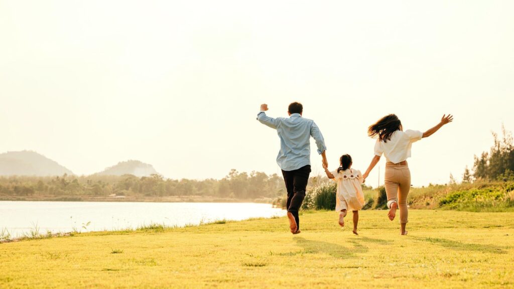 Active lifestyle a group of family running and having fun in a sunny park with green grass and blue sky on a weekend getaway Happy family day